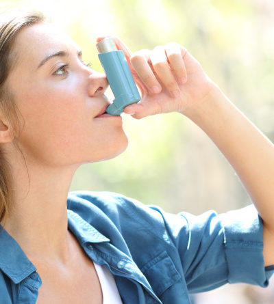 Frau benutzt Asthma-Inhalator