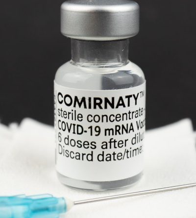 Fläschchen mit COMIRNATY-Impfstoff und Spritze