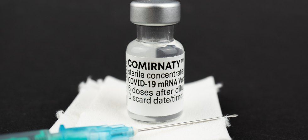 Fläschchen mit COMIRNATY-Impfstoff und Spritze
