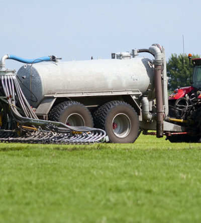 Landwirtschaftliches Fahrzeug düngt ein Feld.