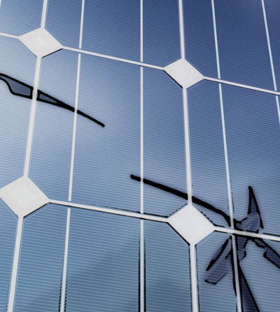 Solarzellen reflektieren den Himmel und einige Windräder