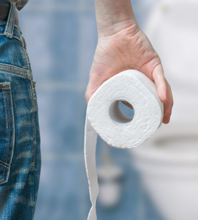 Mann hält Rolle Toilettenpapier in der Hand